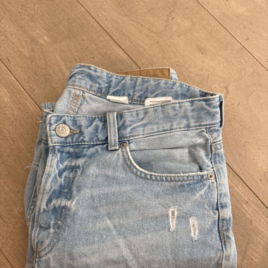 Lange blaue Jeanshose mit Löchern