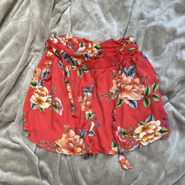 Kurze orangefarbene Shorts mit Blumen
