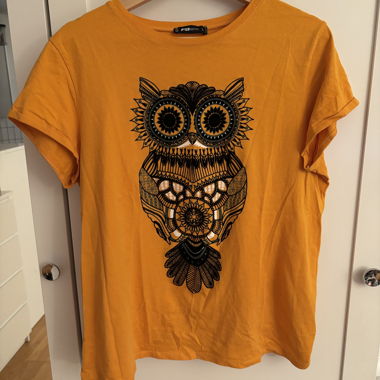 T-shirt arancione con stampa di gufi