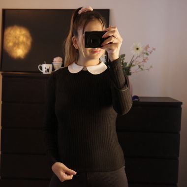 Schwarzer Pulli mit weissem Kragen