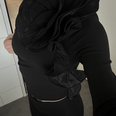 Black one-shoulder top with large flower