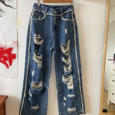 Jeans larghi in denim blu strappati