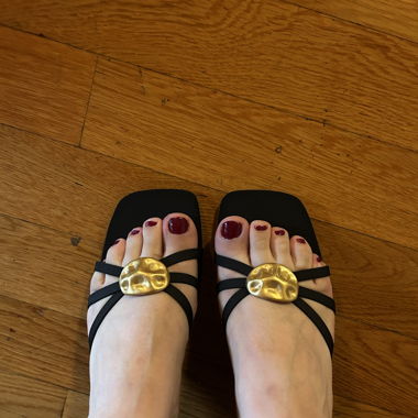 Schwarze Mules mit goldener Brosche
