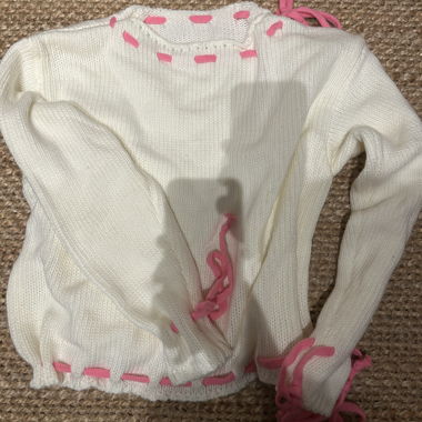White knit sweater with pink details