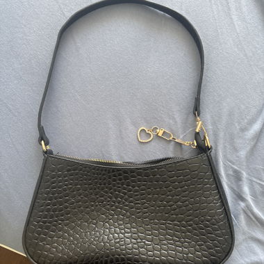 Schwarze Handtasche mit Herzanhaenger