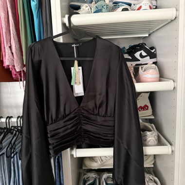 Top nero satinato arricciato a maniche lunghe