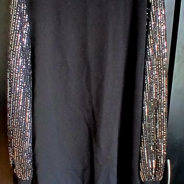 Abito nero con maniche ricoperte di paillettes