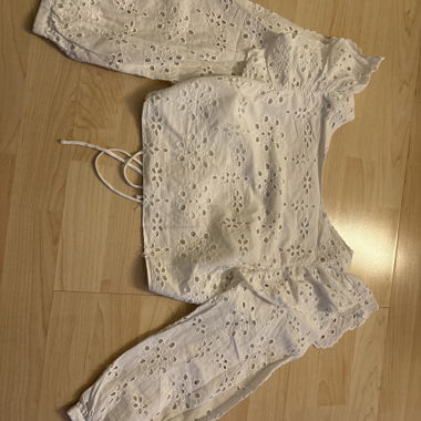 Blusa bianca in pizzo scollata sulla schiena con maniche lunghe