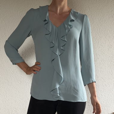 Blusa azzurra con volant