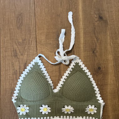 Grünes gestriktes Top mit Blumenmuster.