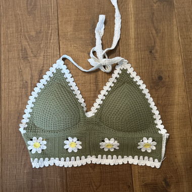 Green knitted top with floral pattern.