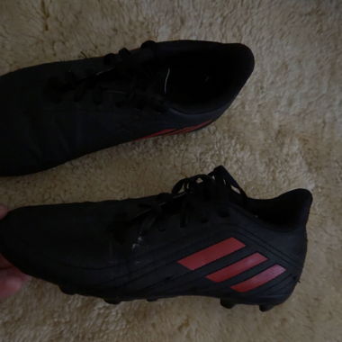 Black football shoes with red stripes
