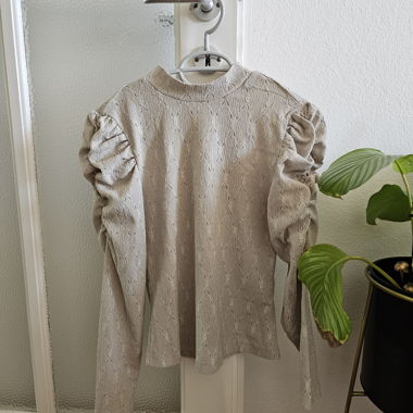 Top beige con maniche a sbuffo