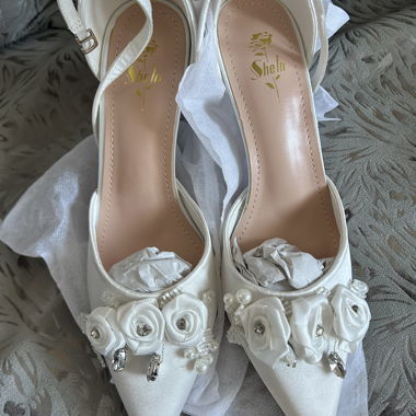 Weisse Pumps mit Blumenverzierung