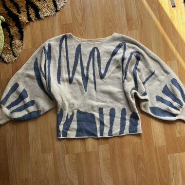 Maglione beige lavorato a maglia con motivo blu