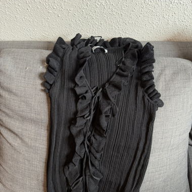 Top in maglia nera con volant