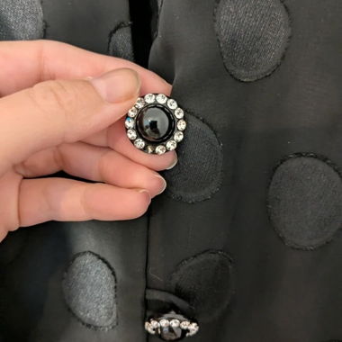 Blusa nera a pois con bottoni gioiello