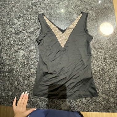 Top nero senza maniche con scollo a V impreziosito da strass dorati