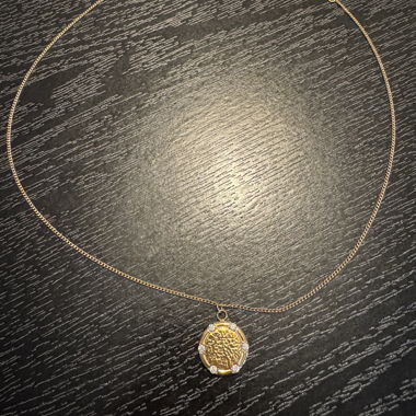 Gold-coloured necklace with round pendant
