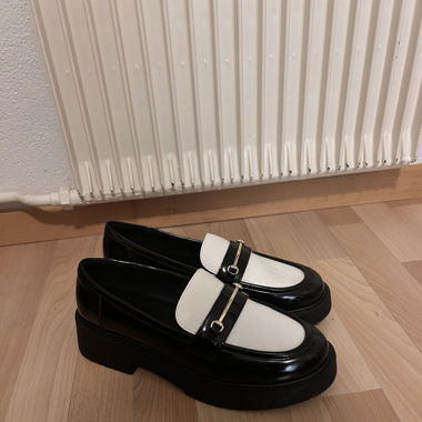 Black and white loafers with a touch of gold