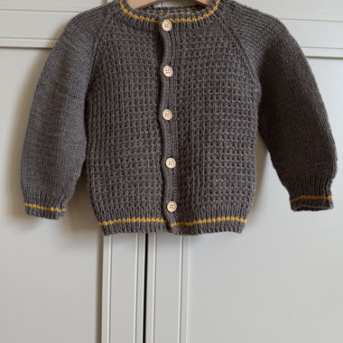 Cardigan neonato lavorato a mano in 100% lana merino