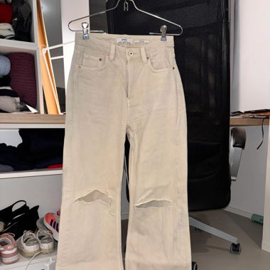 Jean beige troué aux genoux