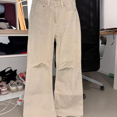 Jean beige troué aux genoux