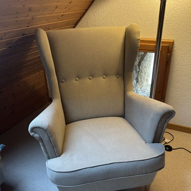 Poltrona a orecchie beige con rivestimento in velluto a coste