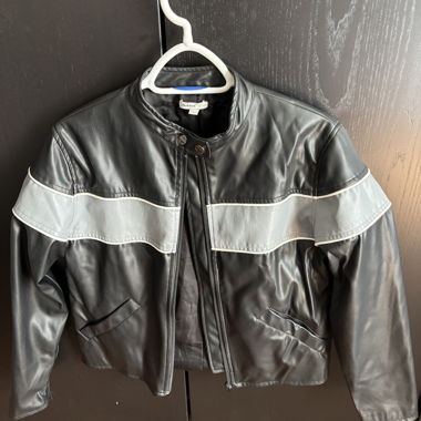 Giacca nera in finta pelle con fascia riflettente discreta