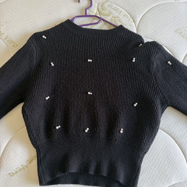 Schwarzer Strickpullover mit Perlen