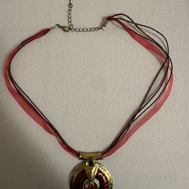 Gold-colored necklace with red pendant