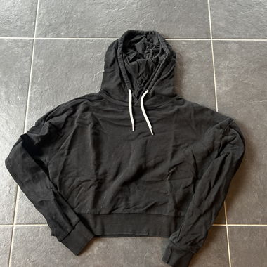 Hoodie noir légèrement court sur le ventre