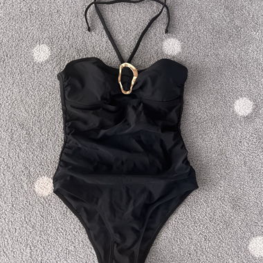 Costume da bagno nero con anello dorato