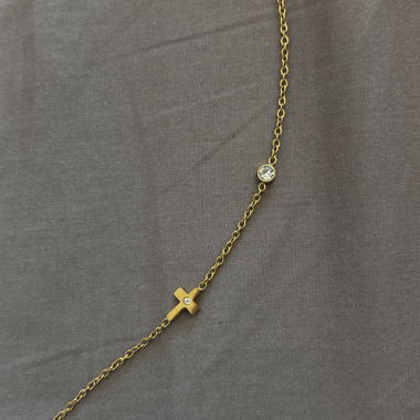 Chaîne en or avec croix et pierre.