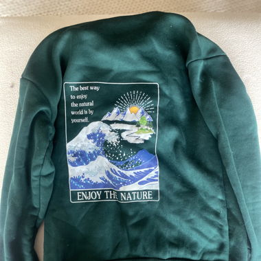 Sweat à capuche vert avec design sur le dos 
