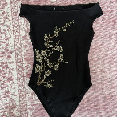 Black off-shoulder bodysuit with floral pattern