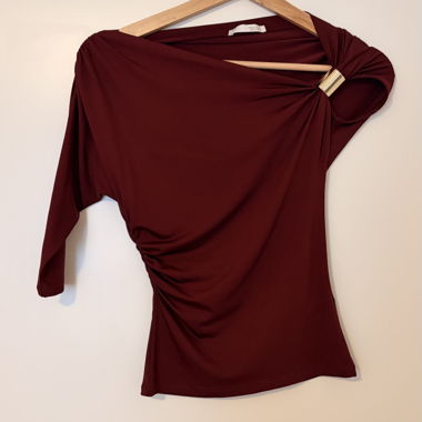 Top asimmetrico bordeaux con gioielli 