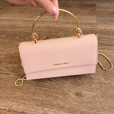 Borsa a tracolla rosa con manico dorato