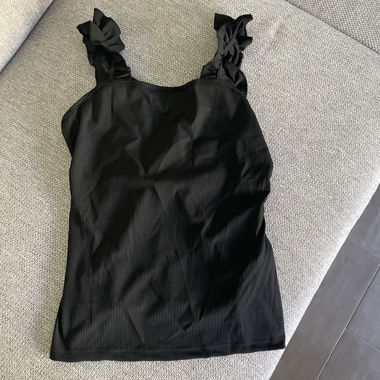 Top nero con spalline a balze