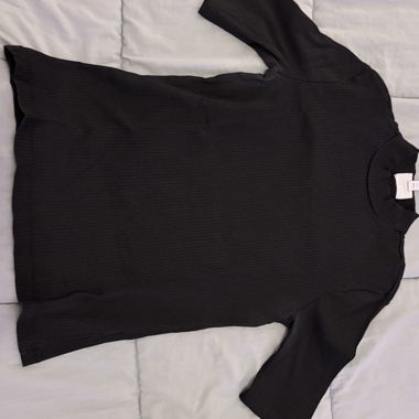 T-shirt nera a coste, taglio aderente con maniche a metà braccio.