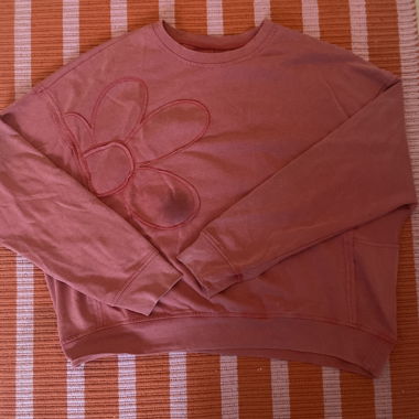 Maglione rosso con fiore (macchia causata dalla fotocamera)