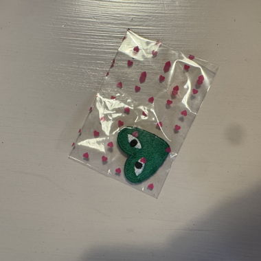 Broche verte avec logo Comme des Garçons