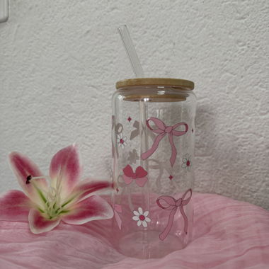 Glas aus Glas mit Schneeflocken und Gänseblümchen