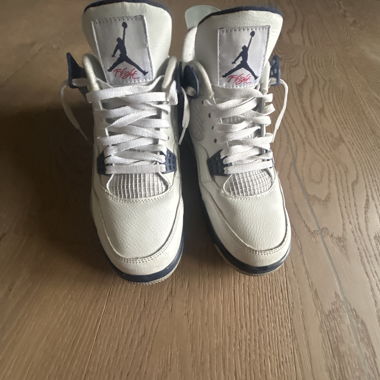 White Nike Air Jordan sneakers with dark blue details and classic Jumpman logo on the tongue.