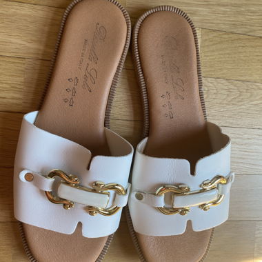 White slip-on sandals with gold buckle
