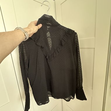 Blusa nera trasparente con volant