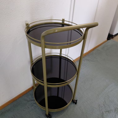 Goldfarbener Rollwagen mit Glas
