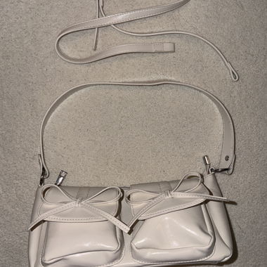Borsa bianca con tasche e fiocchi