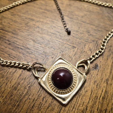 Collana dorata con pietra rossa