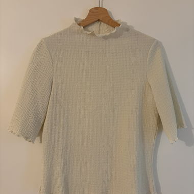 Top a coste bianco con collo a onde